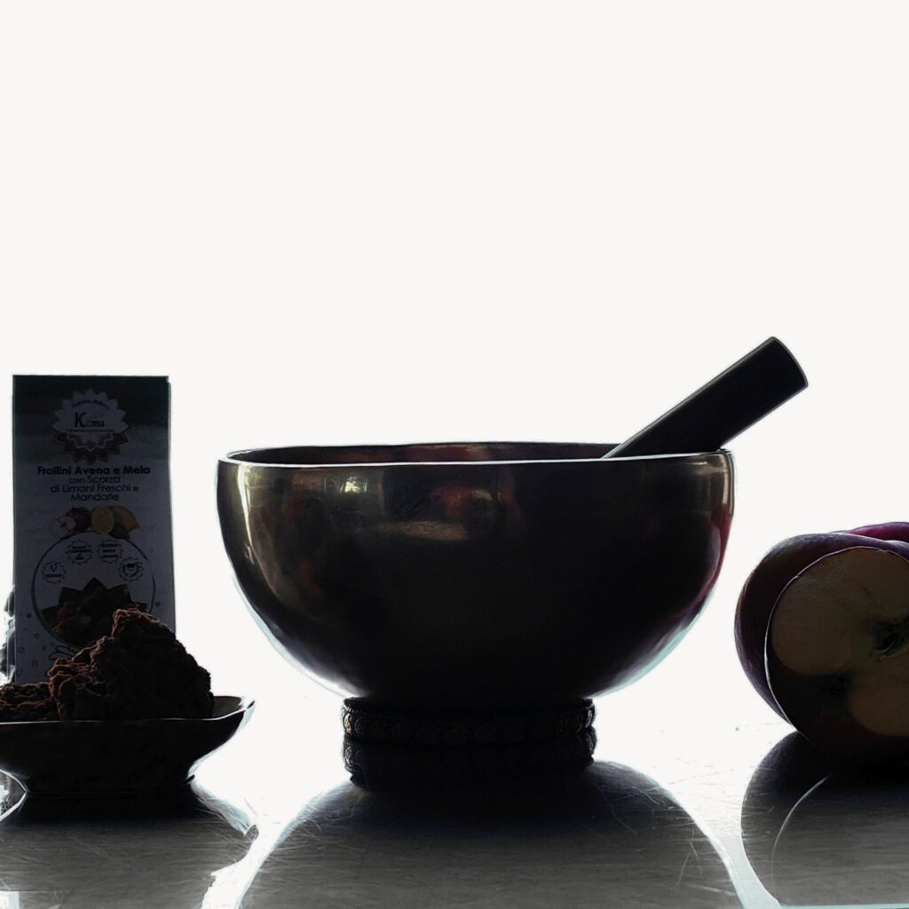 Campana tibetana con biscotti artigianali Kama e ingredienti naturali, simbolo della filosofia olistica: cibo per il corpo e per l’anima.